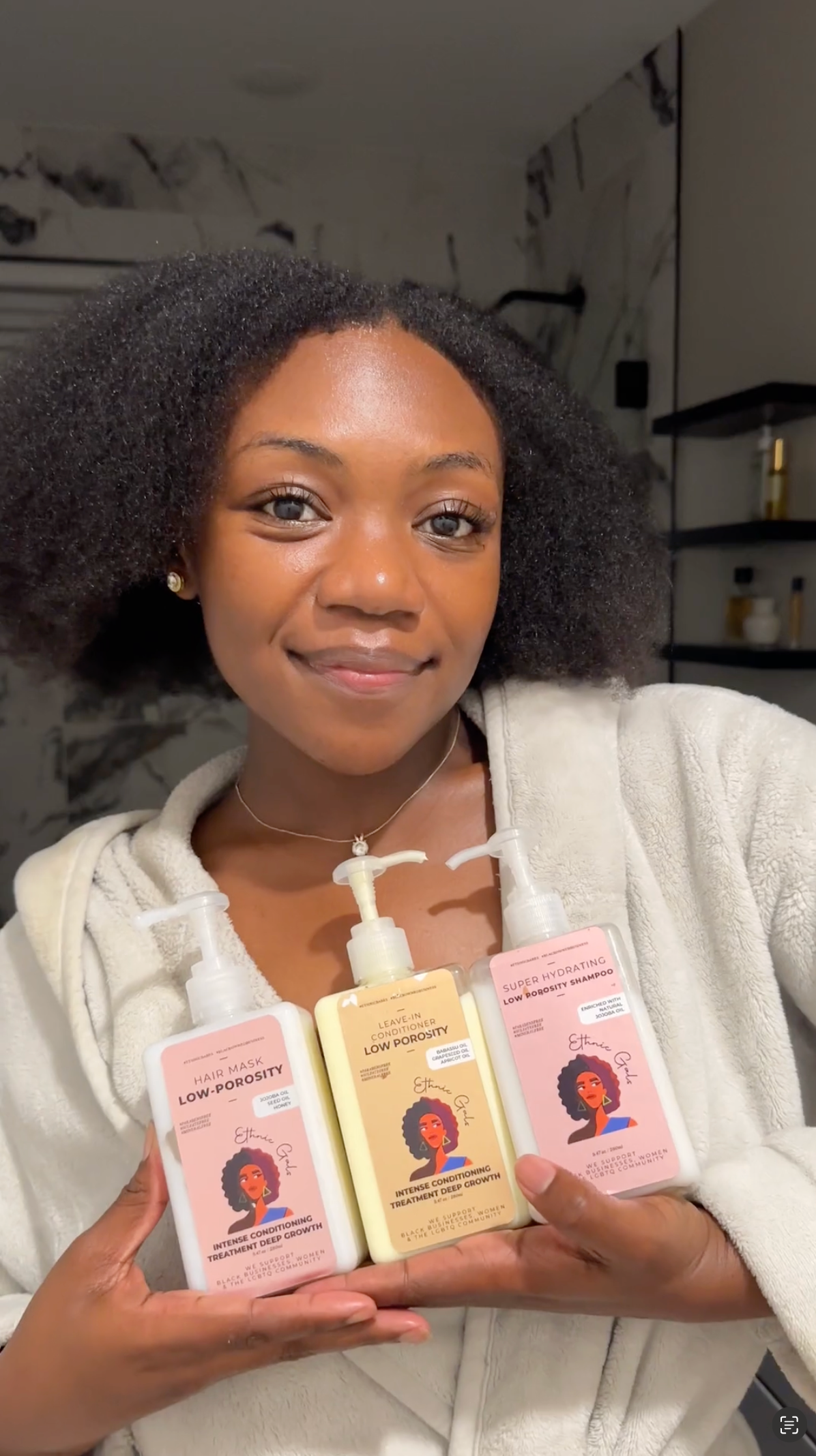 Woman holding three bottles of Ethnic Gals.