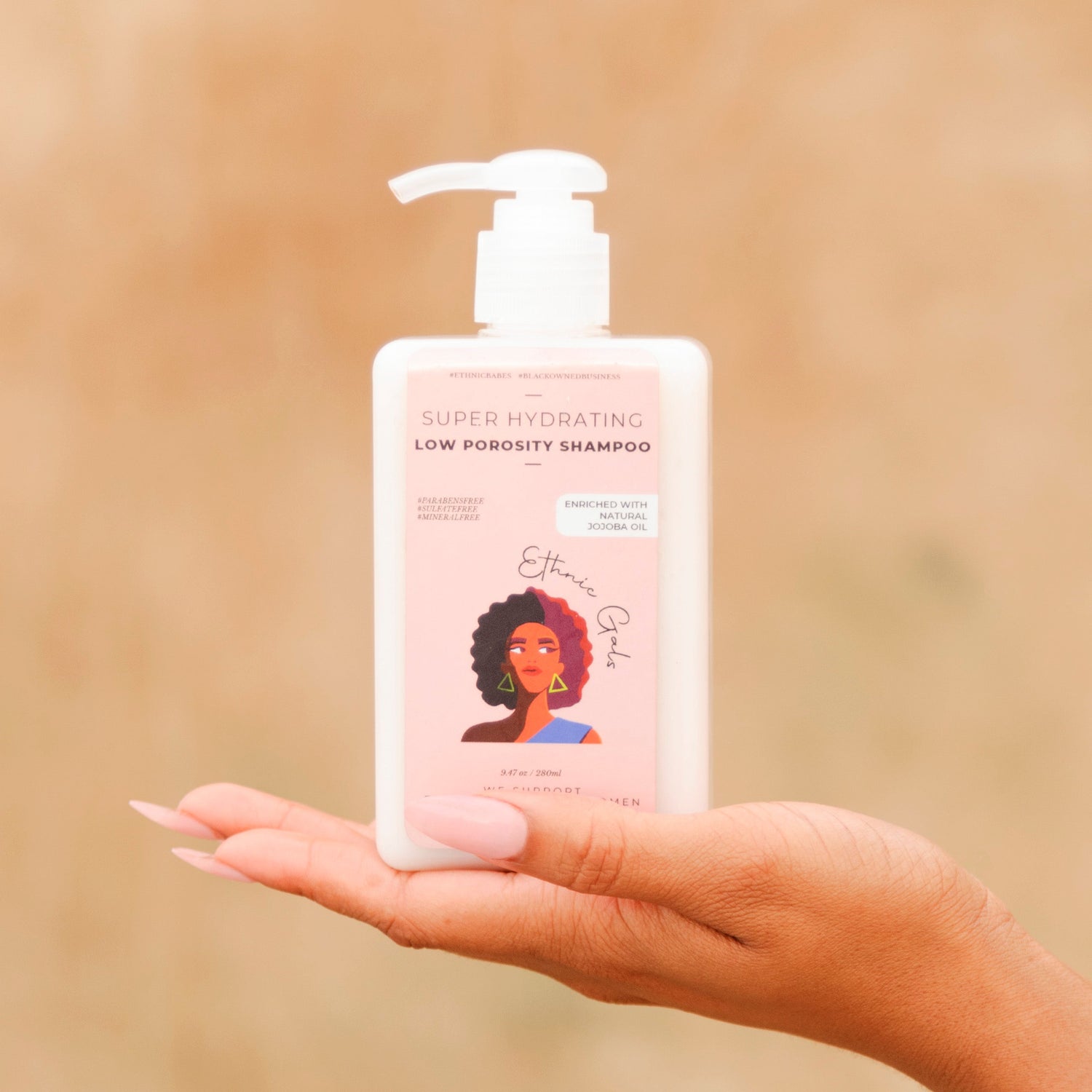 Hand holding a bottle of 'Curly Girl' shampoo against a beige background
