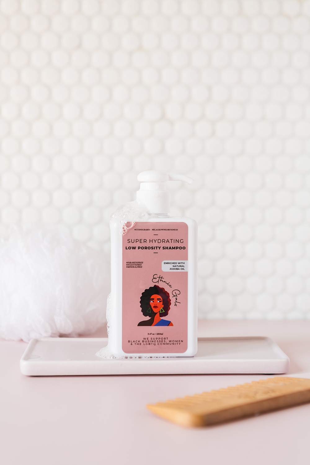 Shampoo bottle with pink label featuring a woman's face on a white textured background