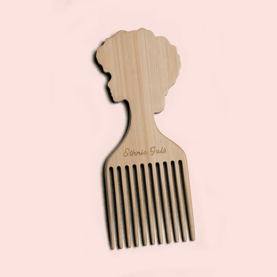 Wooden comb with a silhouette of a woman's head on a light pink background