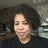 Woman with curly hair wearing a black shirt in an indoor setting